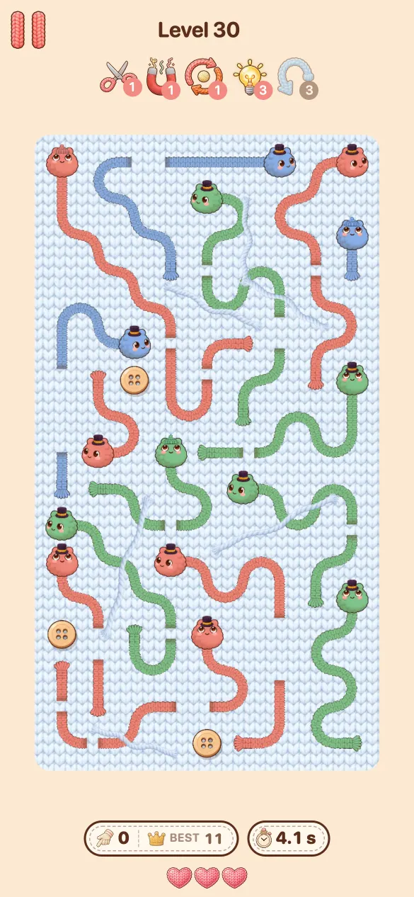 Level 30 in der Sockenschublade: rote, grüne und blaue Tanglings mit langen welligen Körpern auf einem blauen gestrickten Feld.